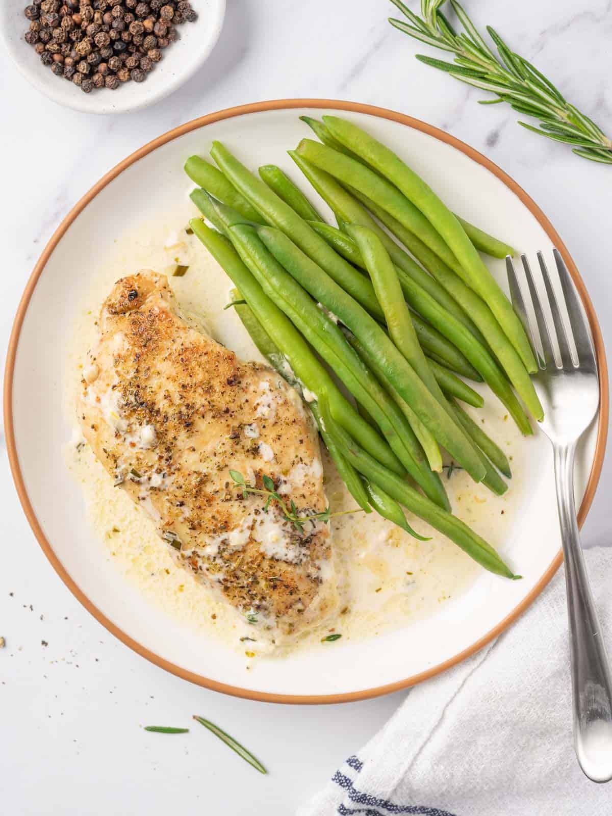 A plate of creamy garlic herb chicken with green beans.