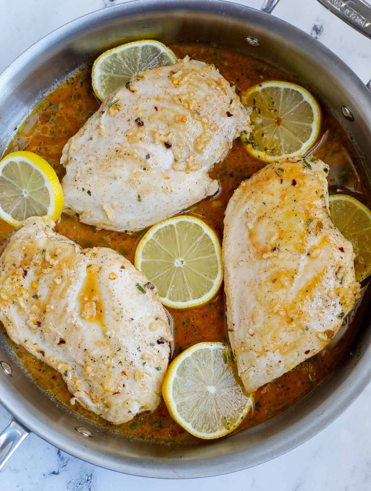 Sauted chicken breasts with lemon rosemary sauce poured over.