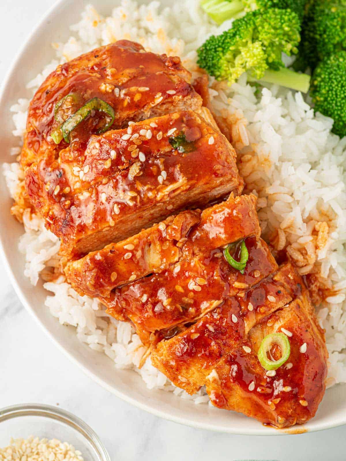 Sliced honey sriracha baked chicken breast served over rice.