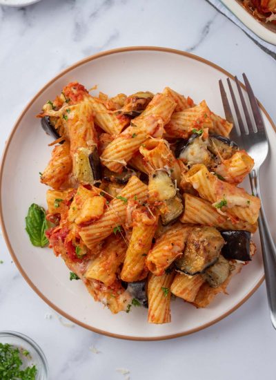 A plate with a pile of spicy eggplant casserole and a fork.