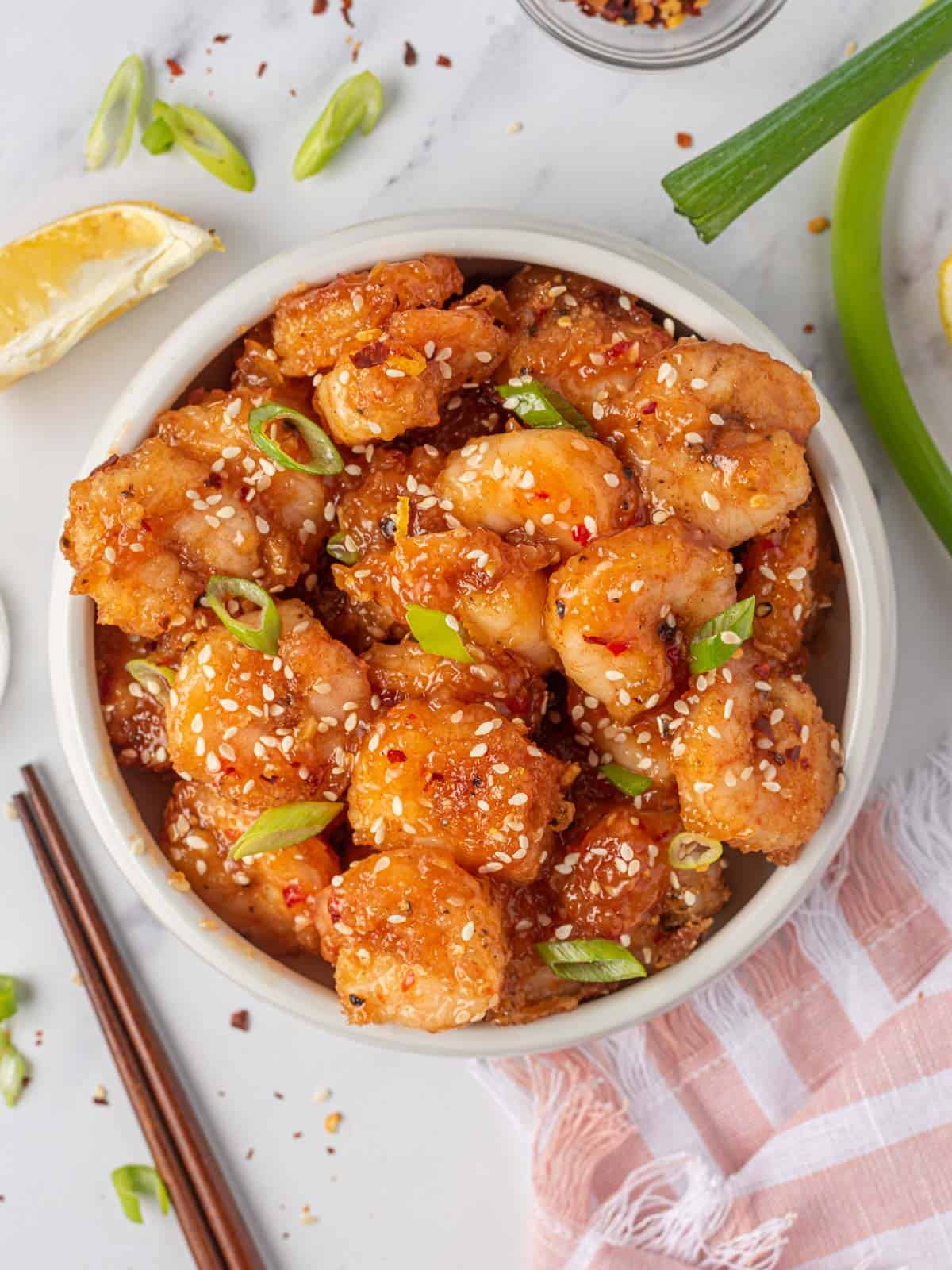 Firecracker shrimp in a serving bowl with chopsticks.