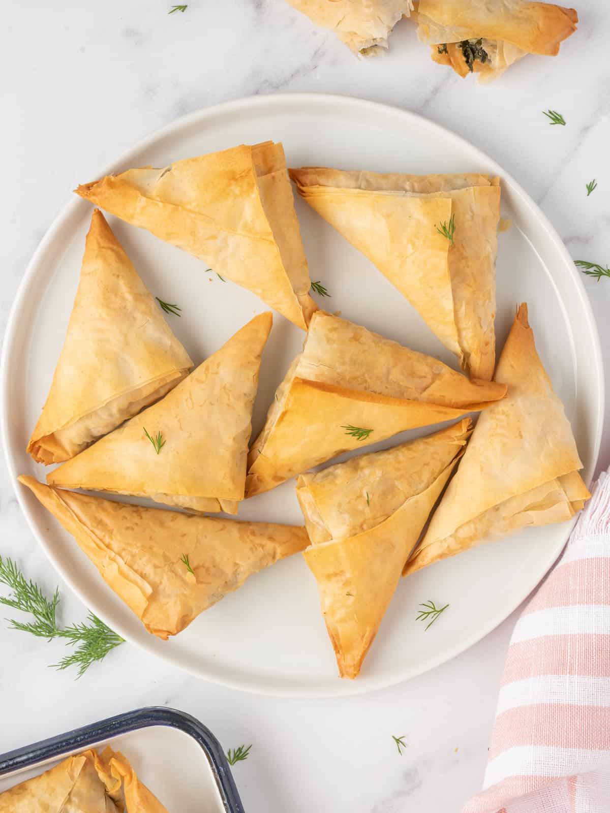 Spinach and feta triangles on a serving platter.