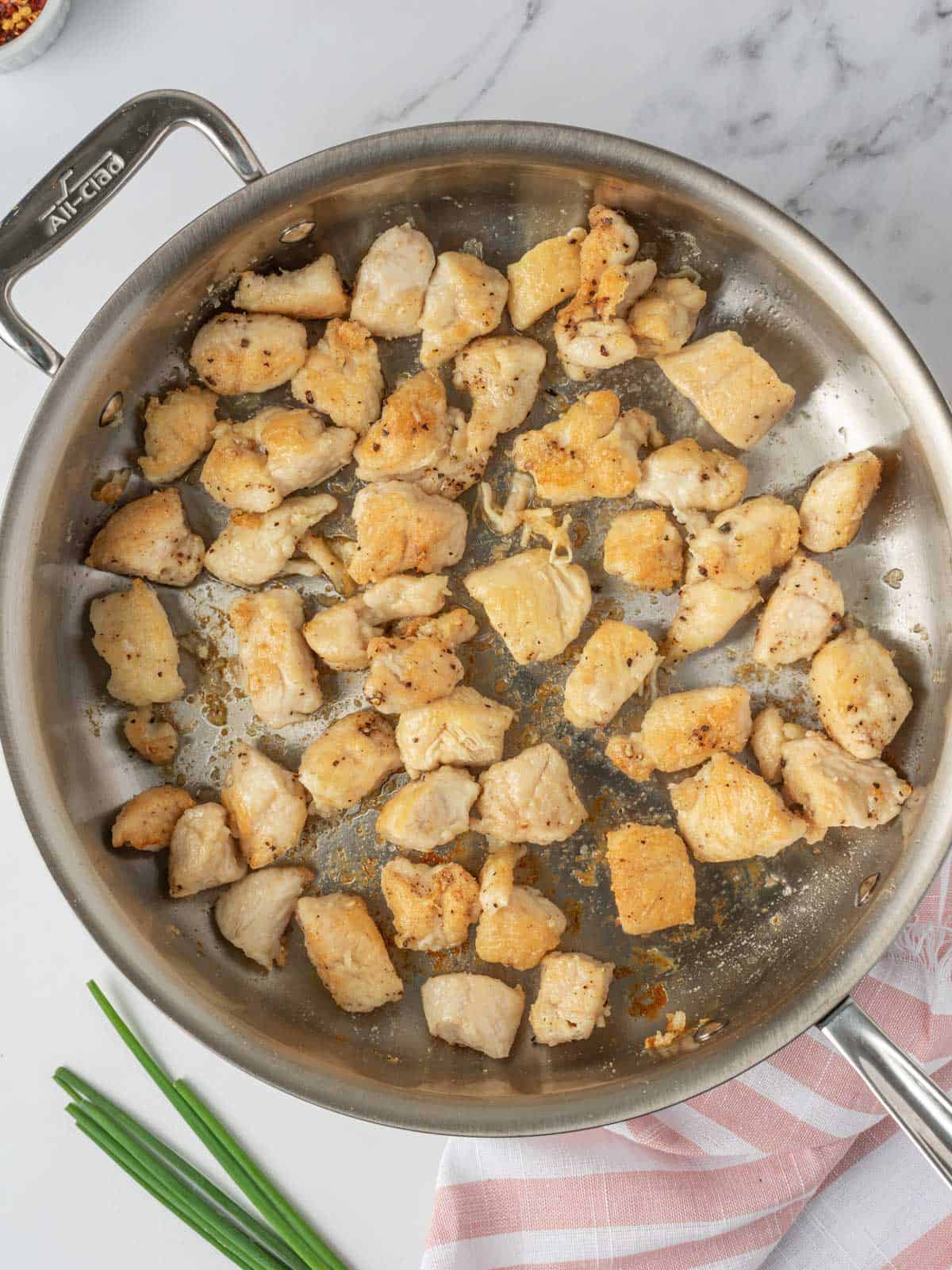 Stir fry chicken in a skillet.