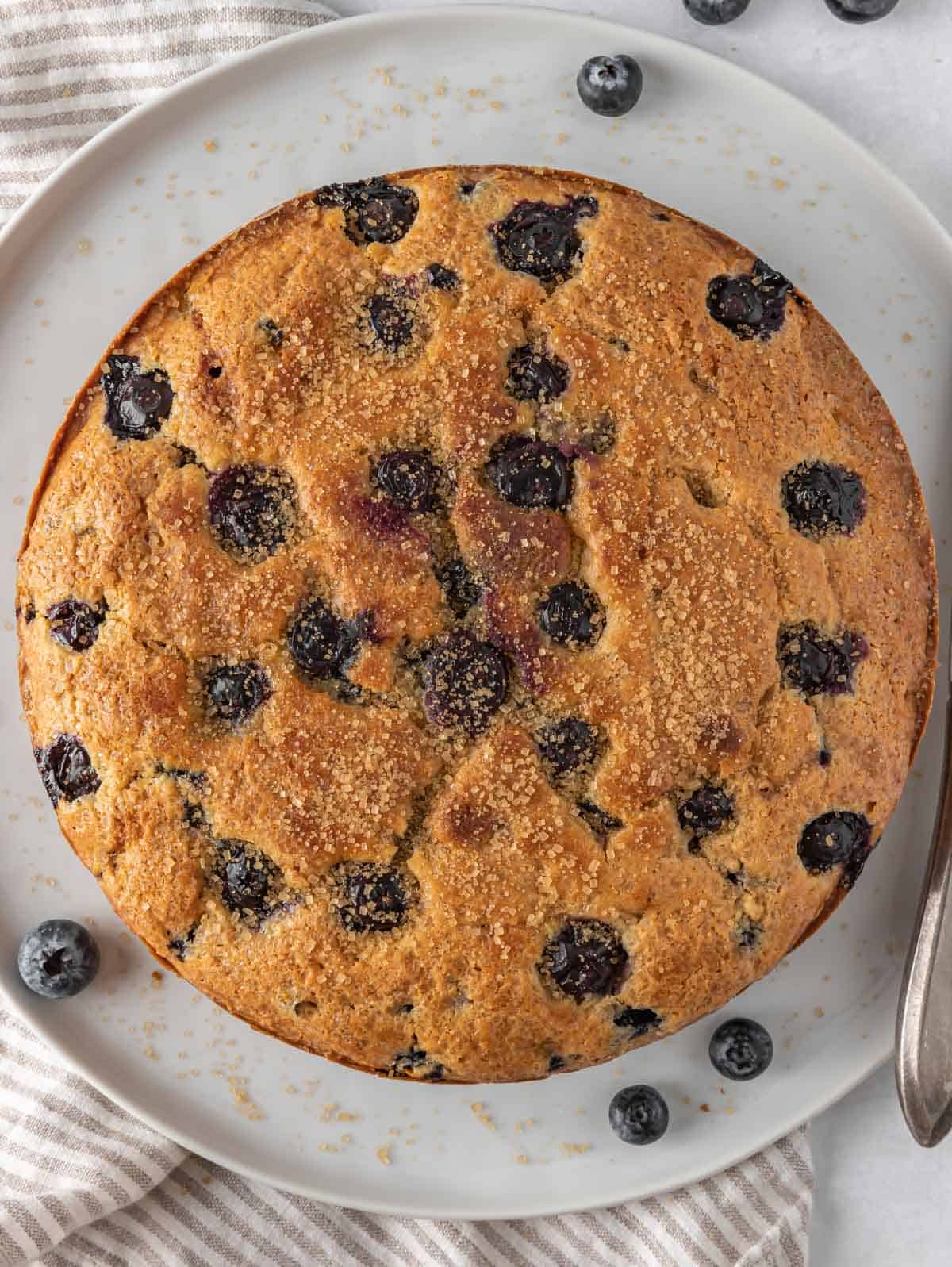 Whole blueberry muffin cake on a platter.