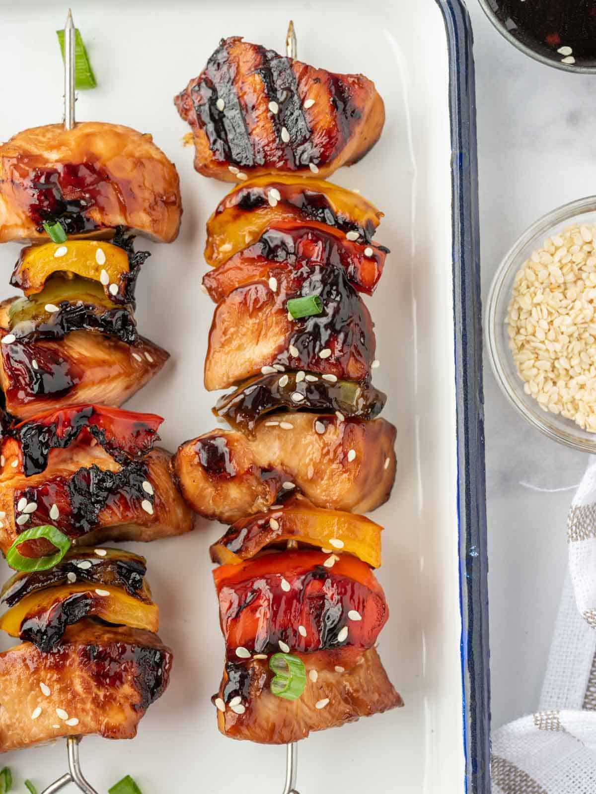 Closeup of a teriyaki chicken kabob on a platter.