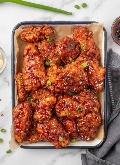 Chicken tenders coated with gochujang sauce on a tray.