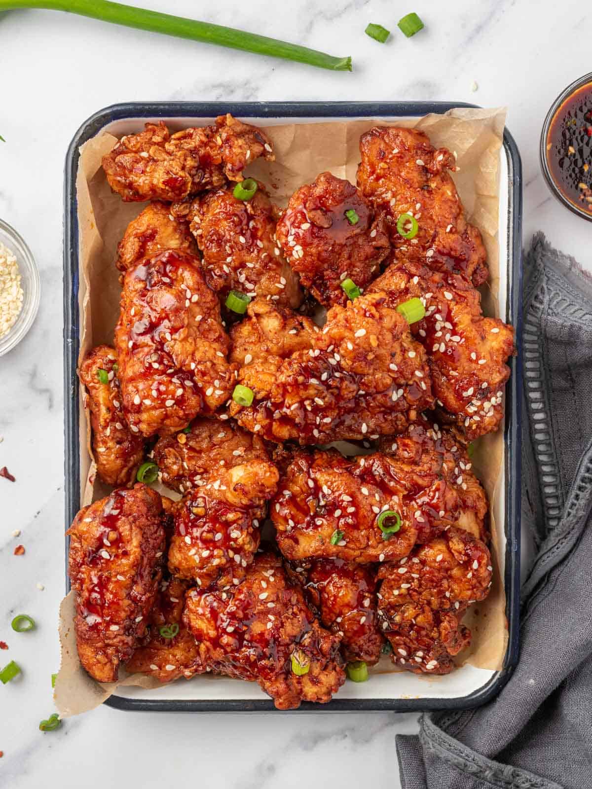 Chicken tenders coated with gochujang sauce on a tray.