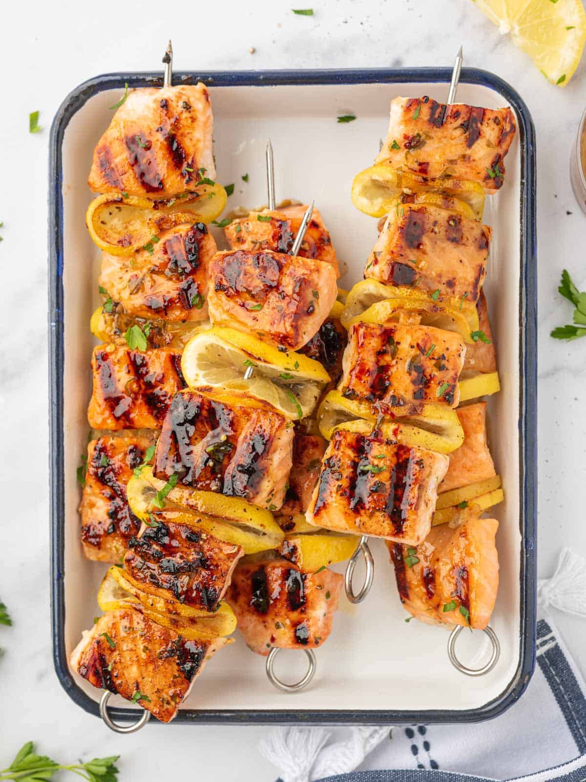 A pile of skewers of grilled salmon with honey glaze.