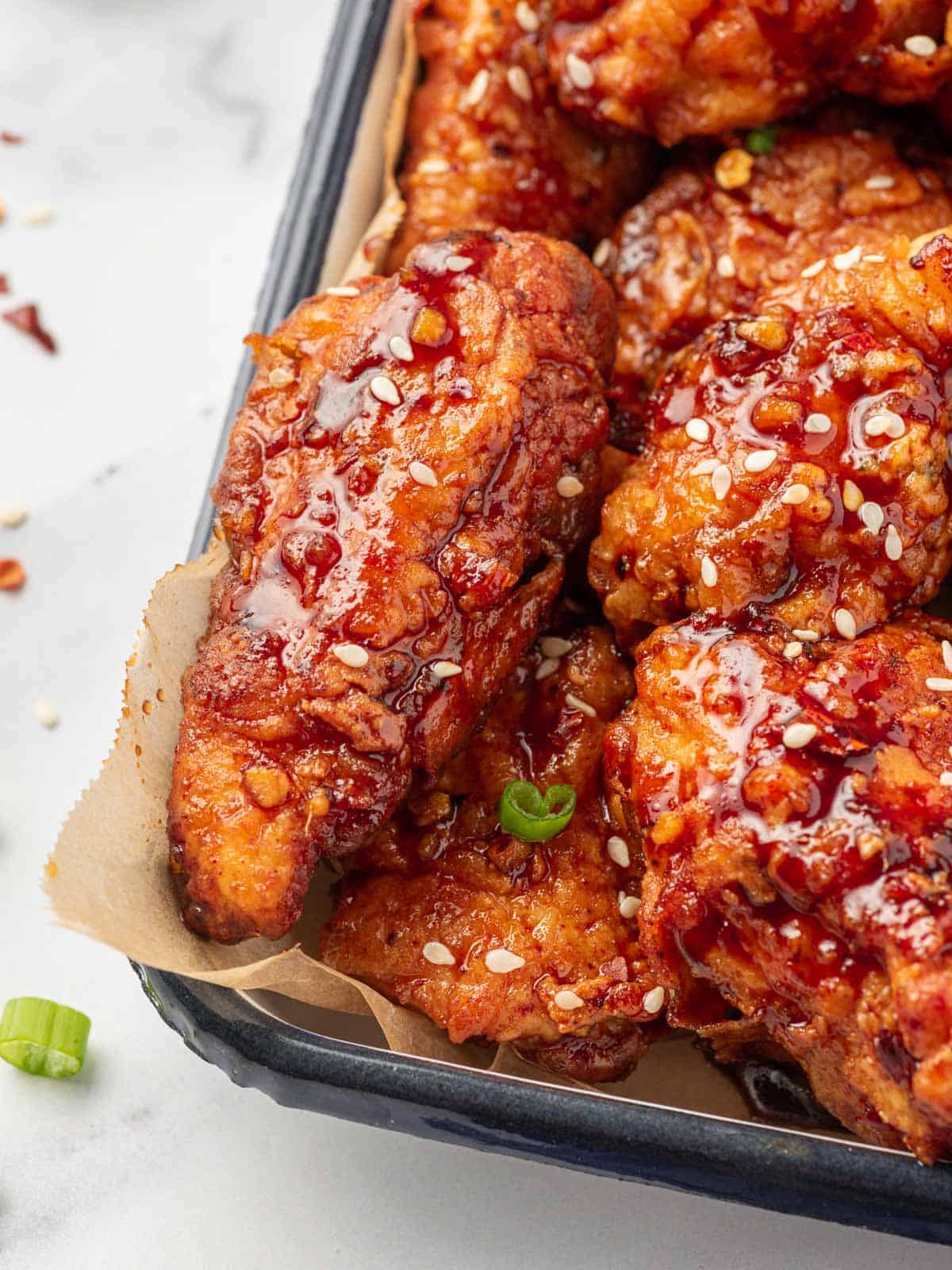 Closeup photo of chicken coated with Gochujang korean chicken sauce.