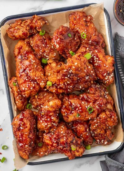 A tray of chicken tenders coated with spicy korean chicken sauce.