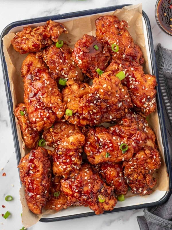A tray of chicken tenders coated with spicy korean chicken sauce.