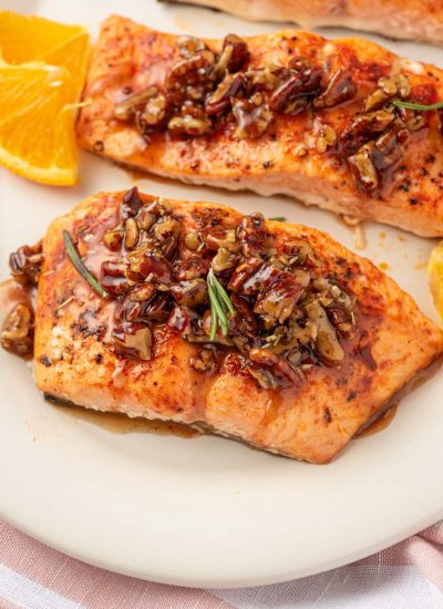 Salmon with maple syrup and pecans on a platter.