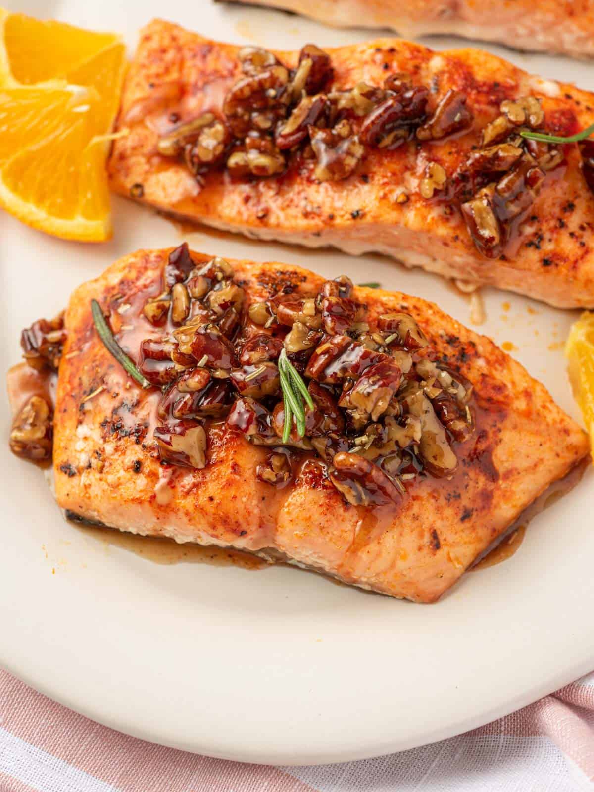 Salmon with maple syrup and pecans on a platter.