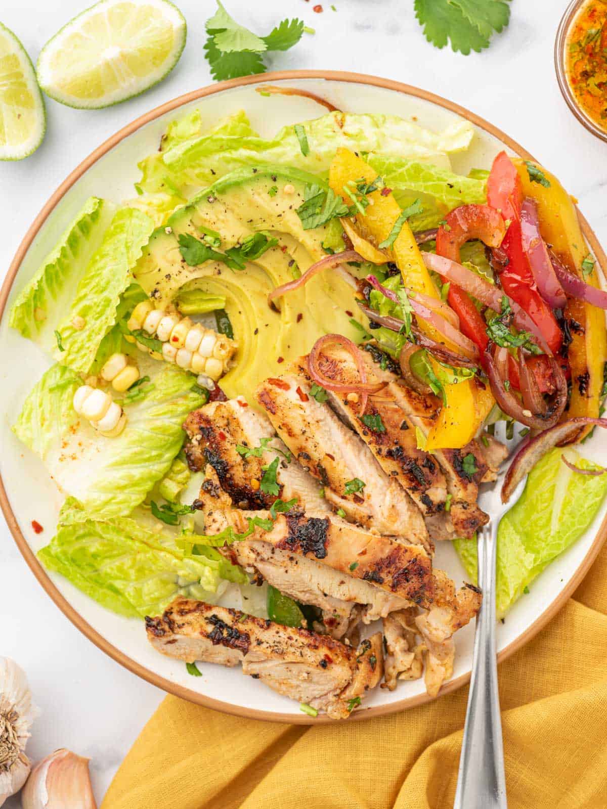 Chicken fajita salad on a plate with a fork.