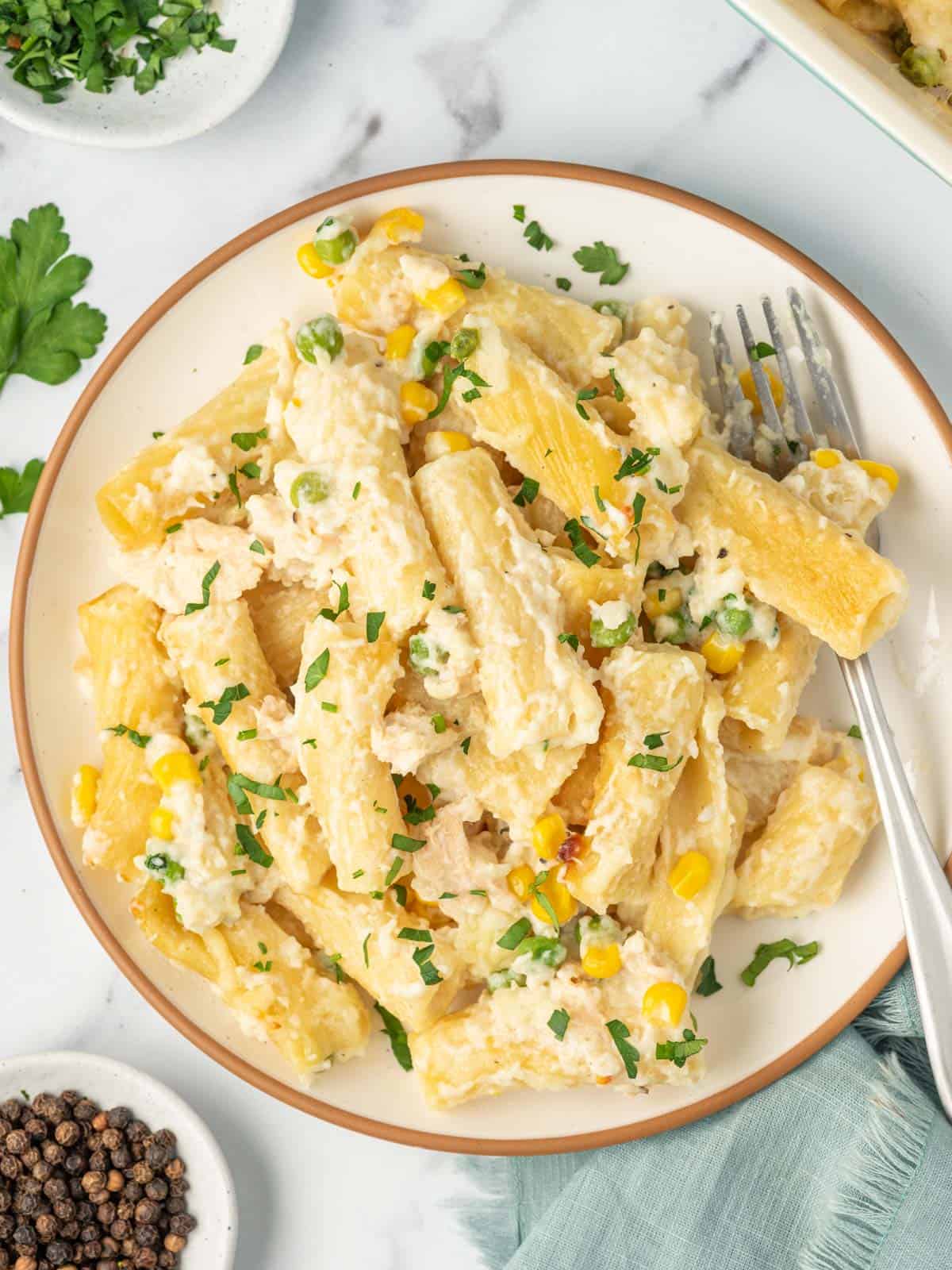 A plate piled with a serving of tuna noodle casserole and a fork.