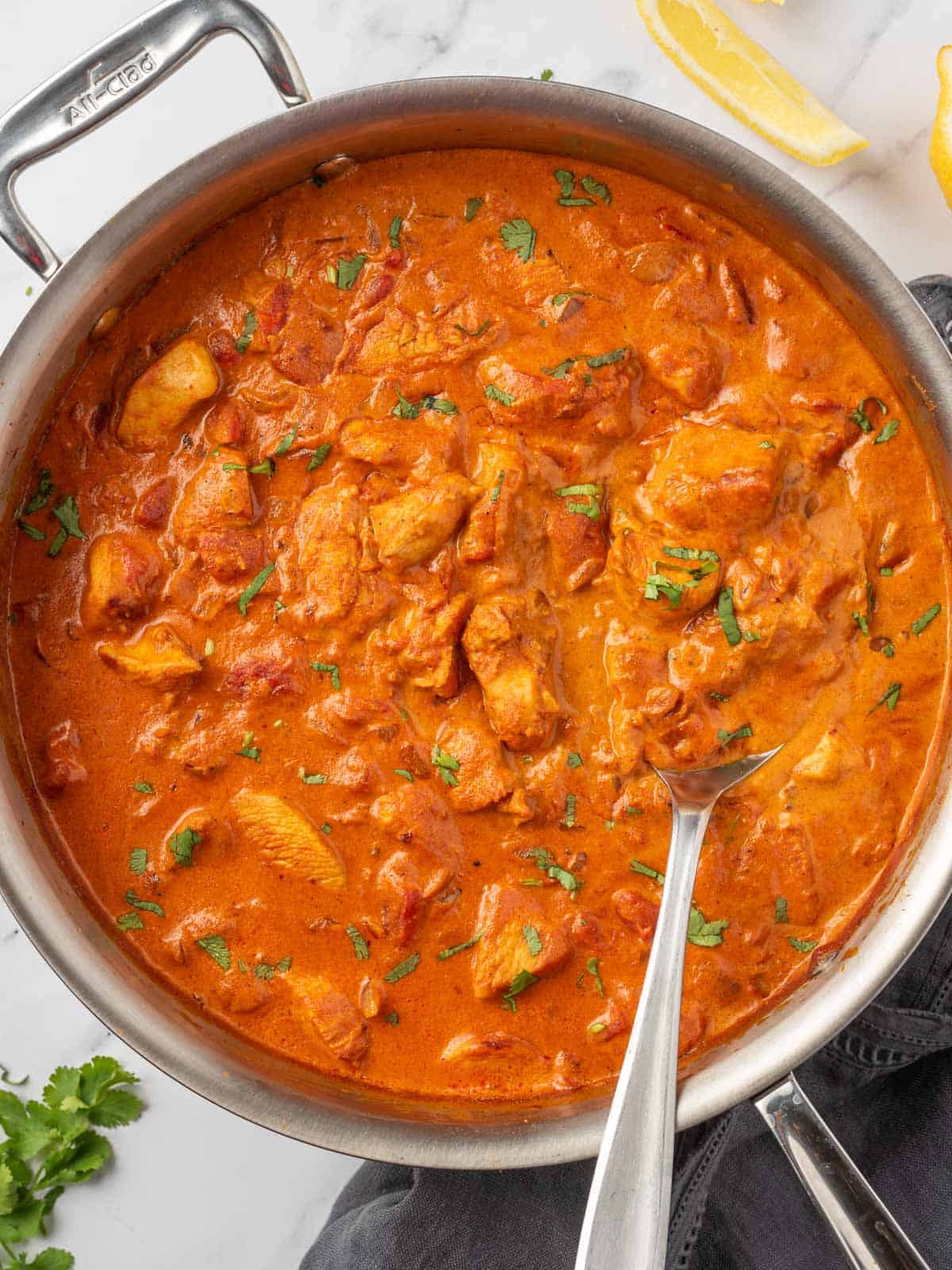 Chicken tikka masala in a pot with a serving spoon.