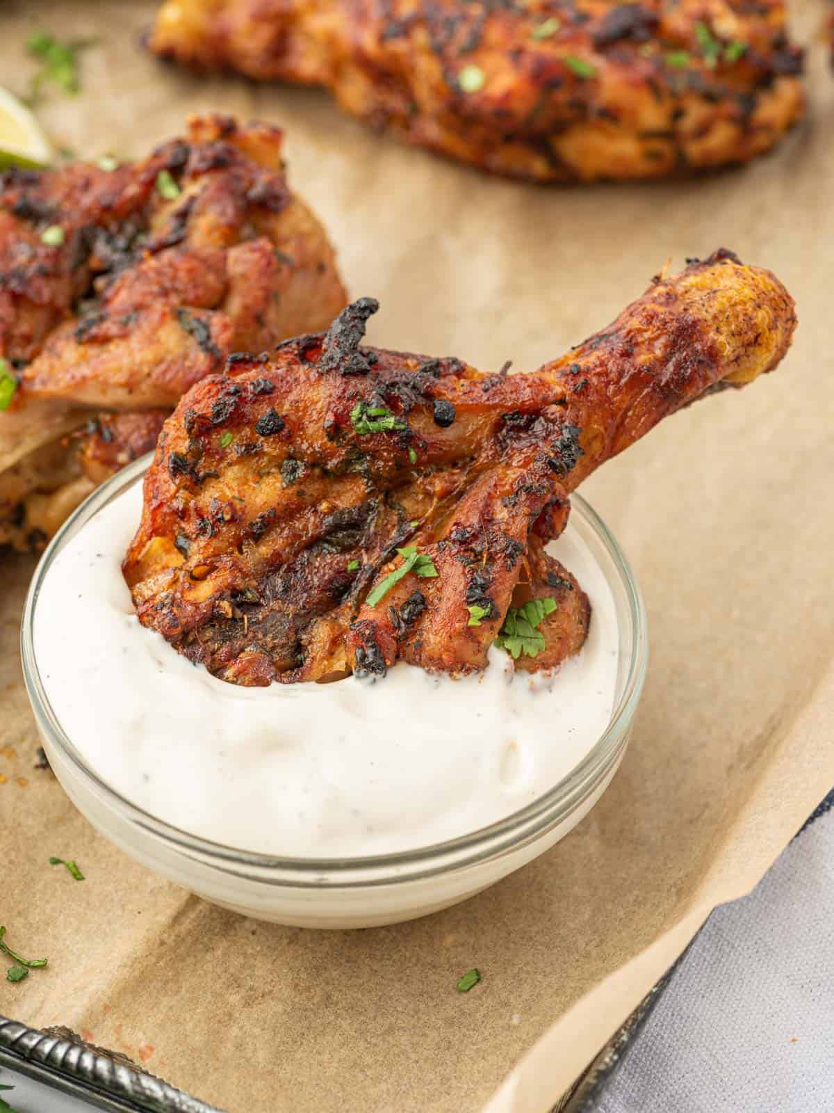 Cilantro lime chicken legs dunked into a creamy dip.