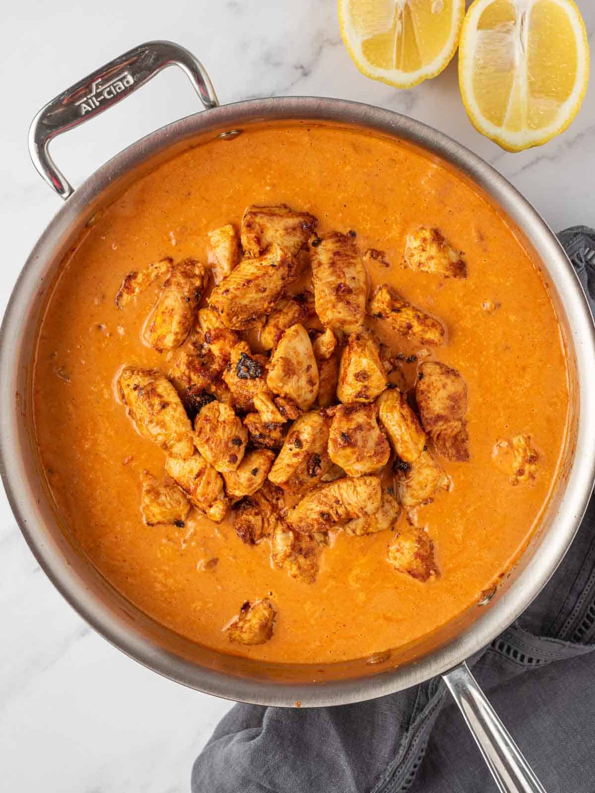 Adding chicken tikka to the rich masala sauce.