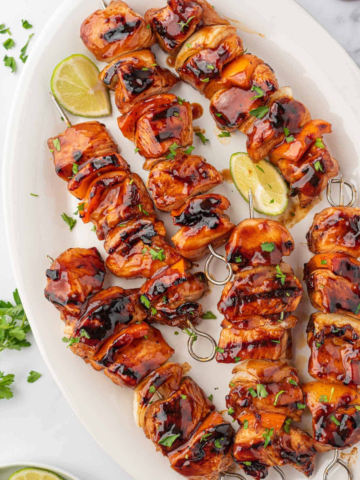 A platter of bbq chicken skewers ready for serving.