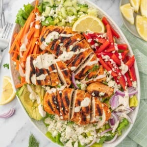 A platter of salad with buffalo chicken.