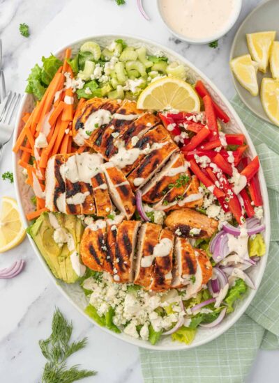 A platter of salad with buffalo chicken.