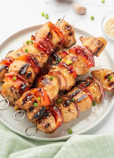 Grilled chicken skewers with honey and garlic on a platter.