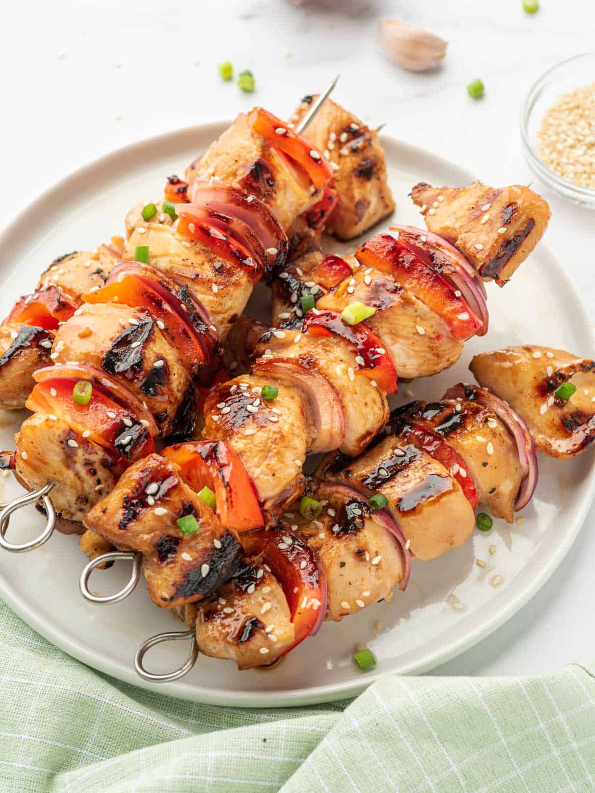 Grilled chicken skewers with honey and garlic on a platter.