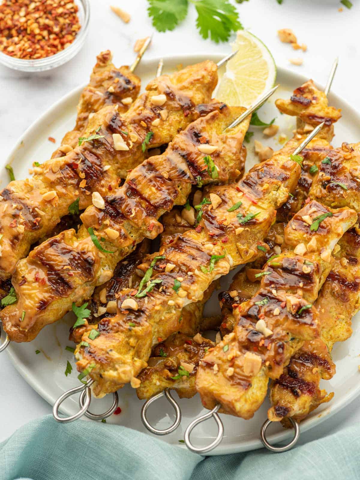Chicken with peanut sauce skewers on a platter.