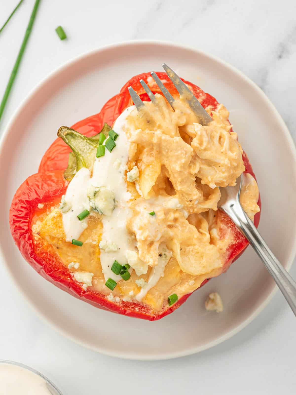 Stuffed buffalo chicken pepper on a plate with a fork.