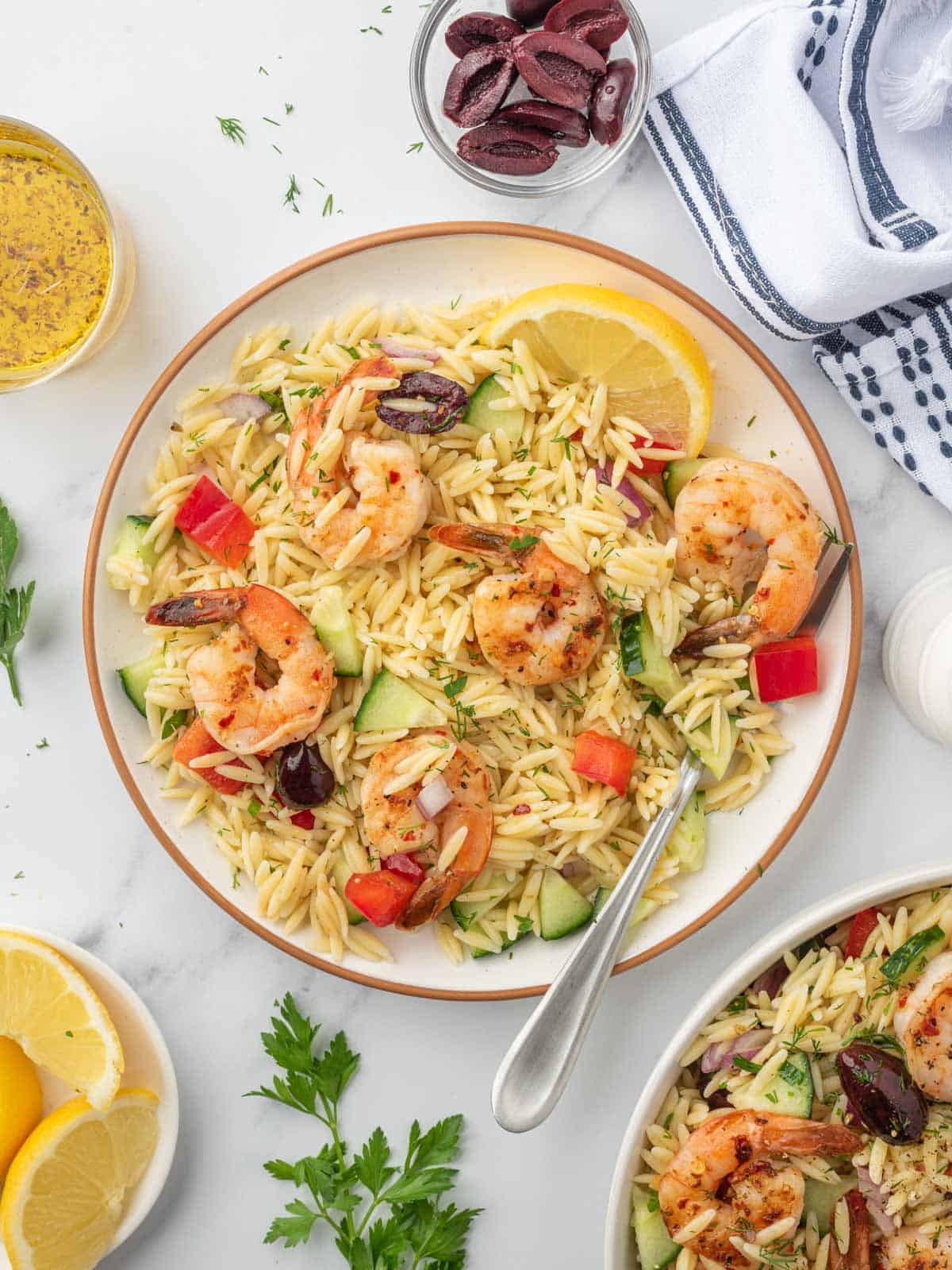 Shrimp orzo salad on a plate with a fork.