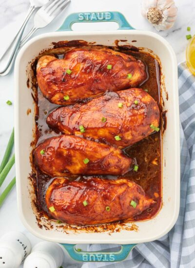 A casserole dish of barbecue baked chicken in oven.