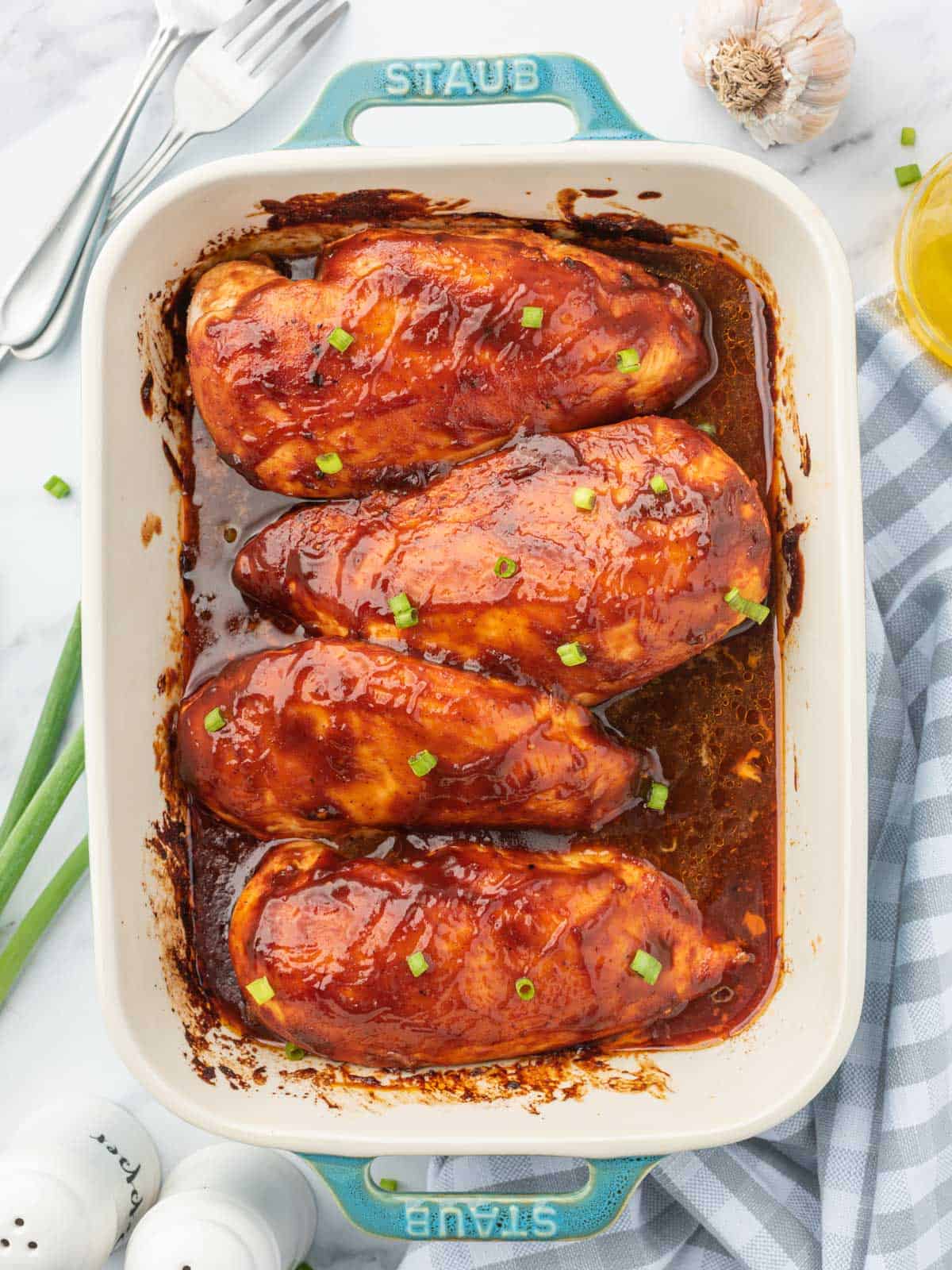 A casserole dish of barbecue baked chicken in oven.