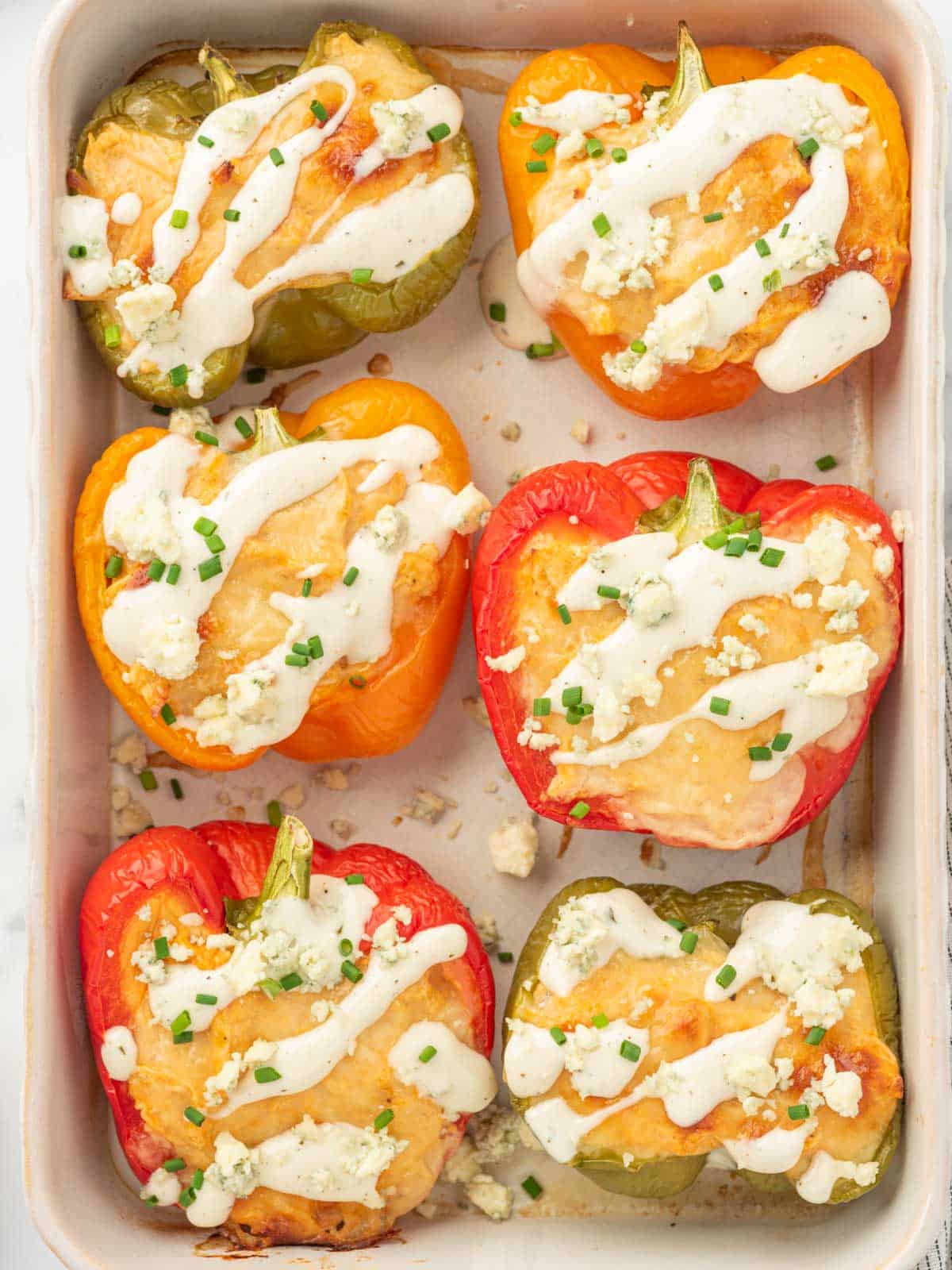 A tray of keto stuffed peppers with chicken and blue cheese crumbles.