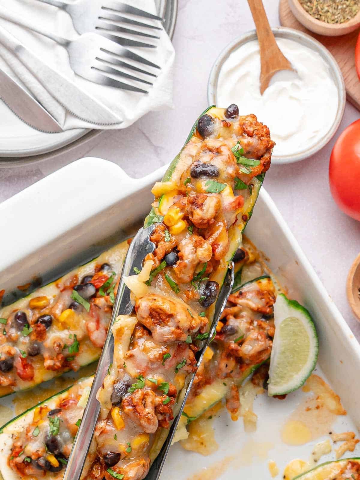 Cheesy zucchini boat filled with seasoned ground turkey, black beans, corn, and tomatoes.