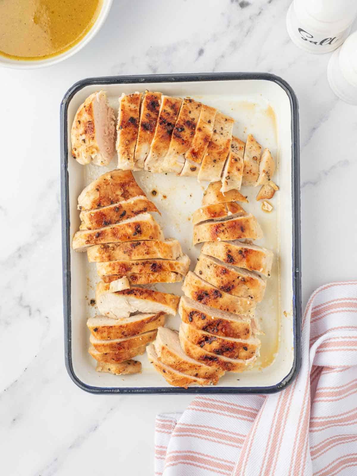 Grilled chicken breasts sliced on a platter.