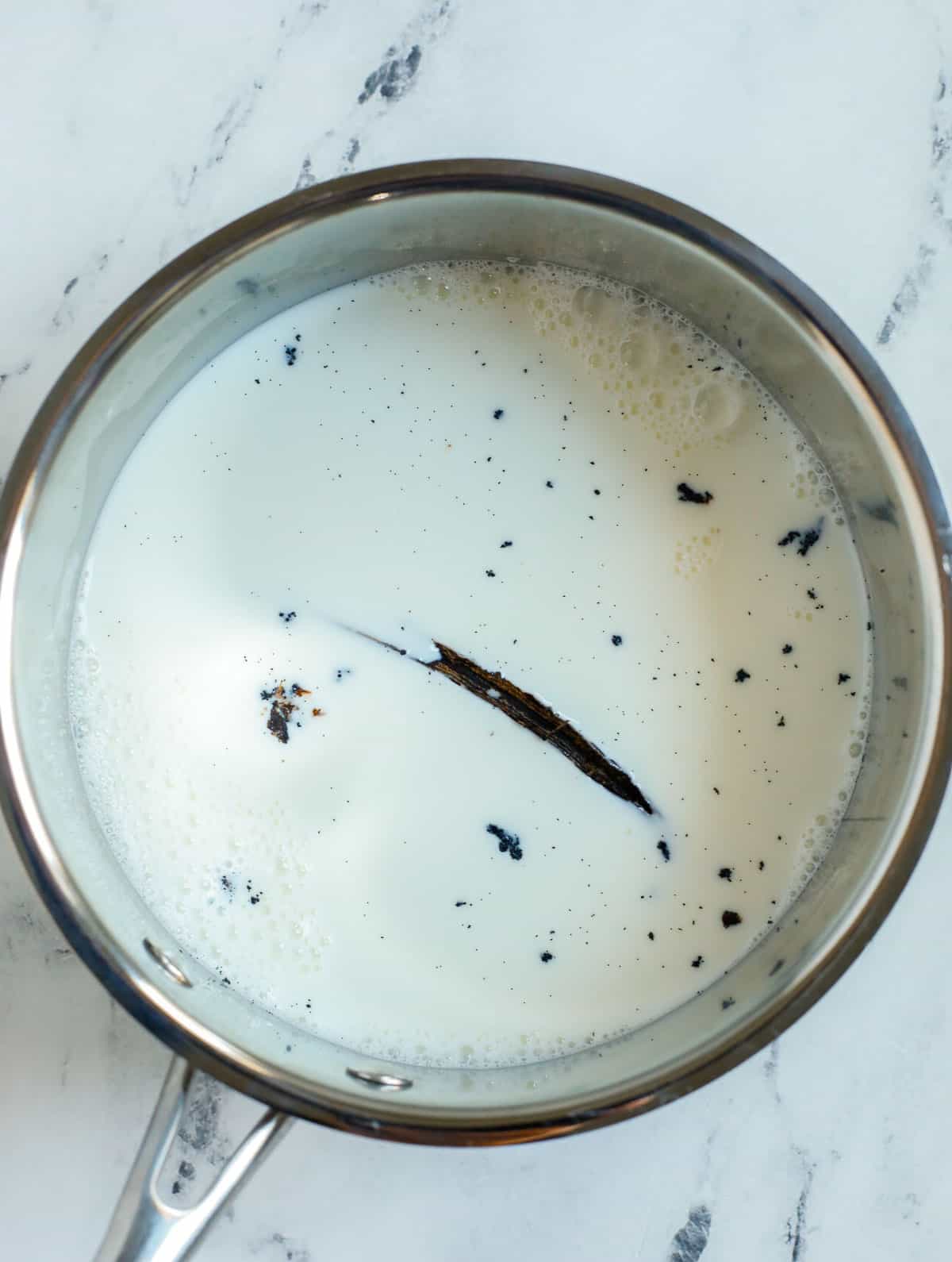 milk in a pot with vanilla bean pod.