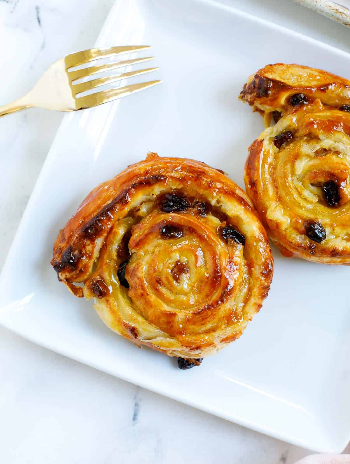 baked pain aux raisins served on a plate.