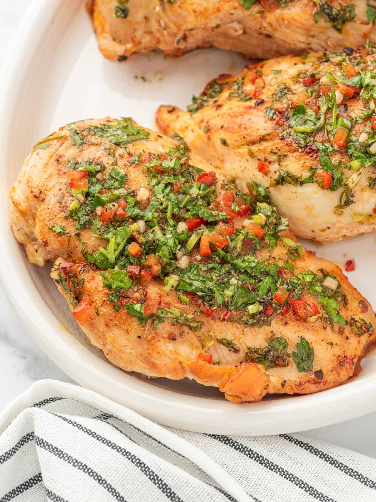 Closeup of chicken with chimichurri sauce.