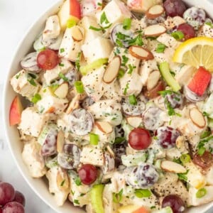 Chicken salad in a bowl topped with slices of almonds.