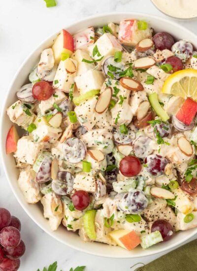 Chicken salad in a bowl topped with slices of almonds.