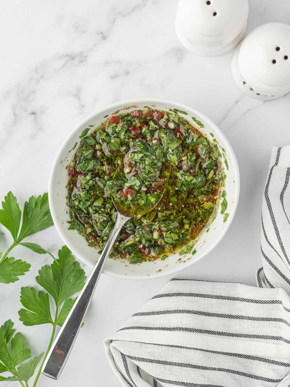 A bowl of fresh chimichurri sauce.