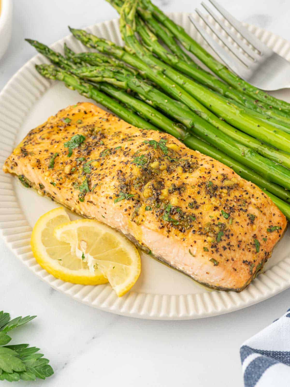 A plate with baked lemon pepper salmon and asparagus.