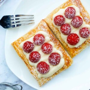 raspberry tart on a plate, dusted with powdered sugar