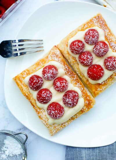 raspberry tart on a plate, dusted with powdered sugar