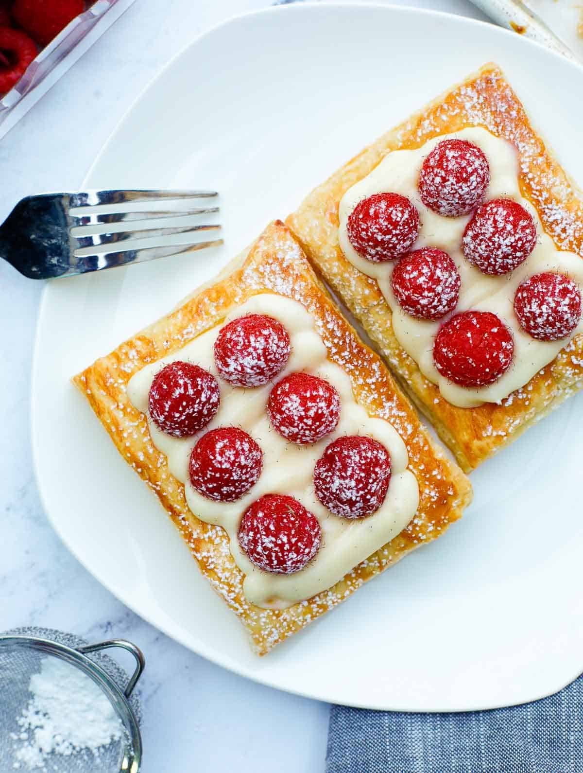 raspberry tart on a plate, dusted with powdered sugar