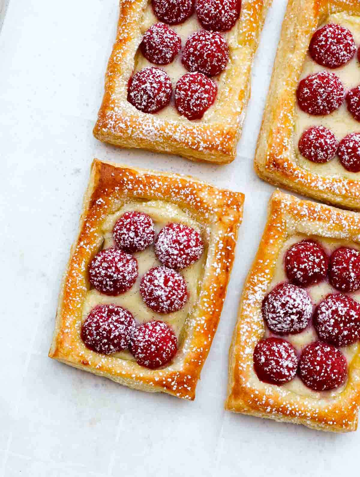raspberry tart baked on a sheet pan, dusted with powdered sugar