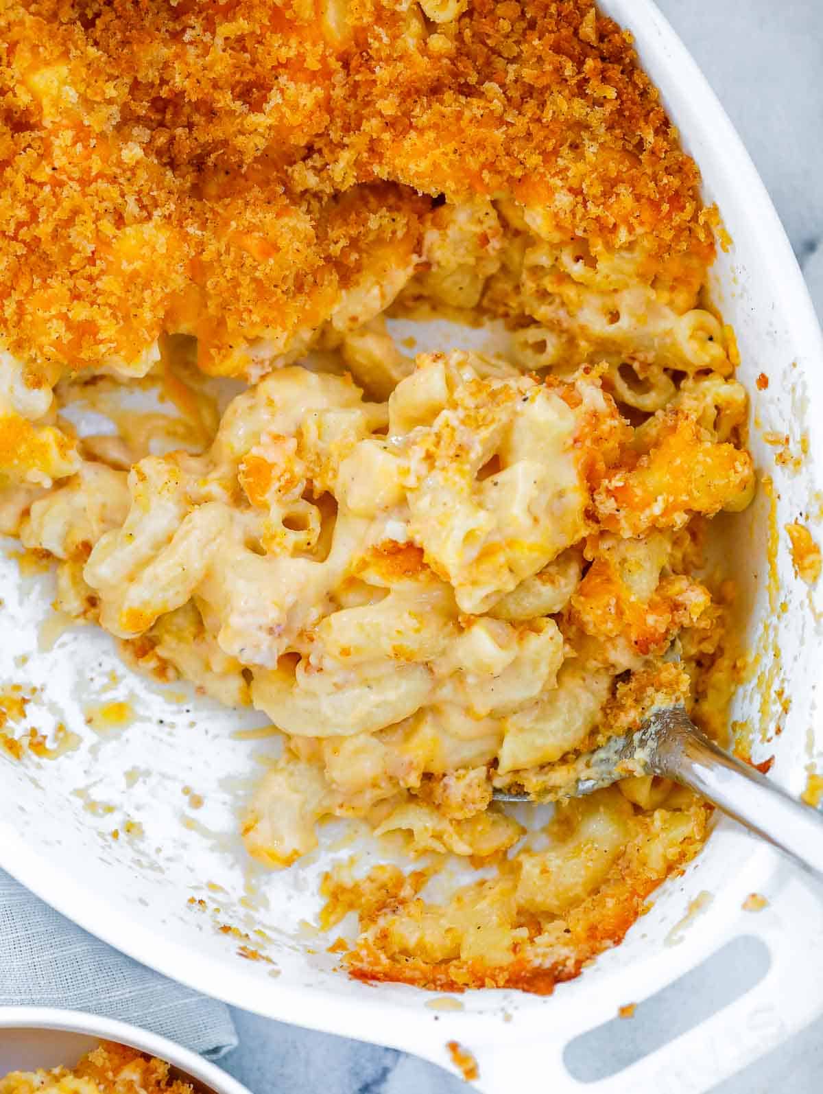 baked mac and cheese with a spoon in the baking dish