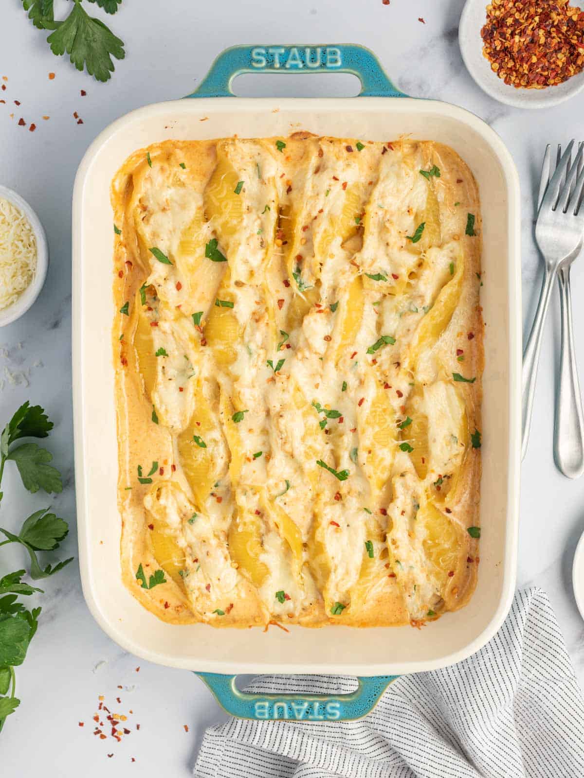 A baking dish with creamy cajun chicken alfredo.