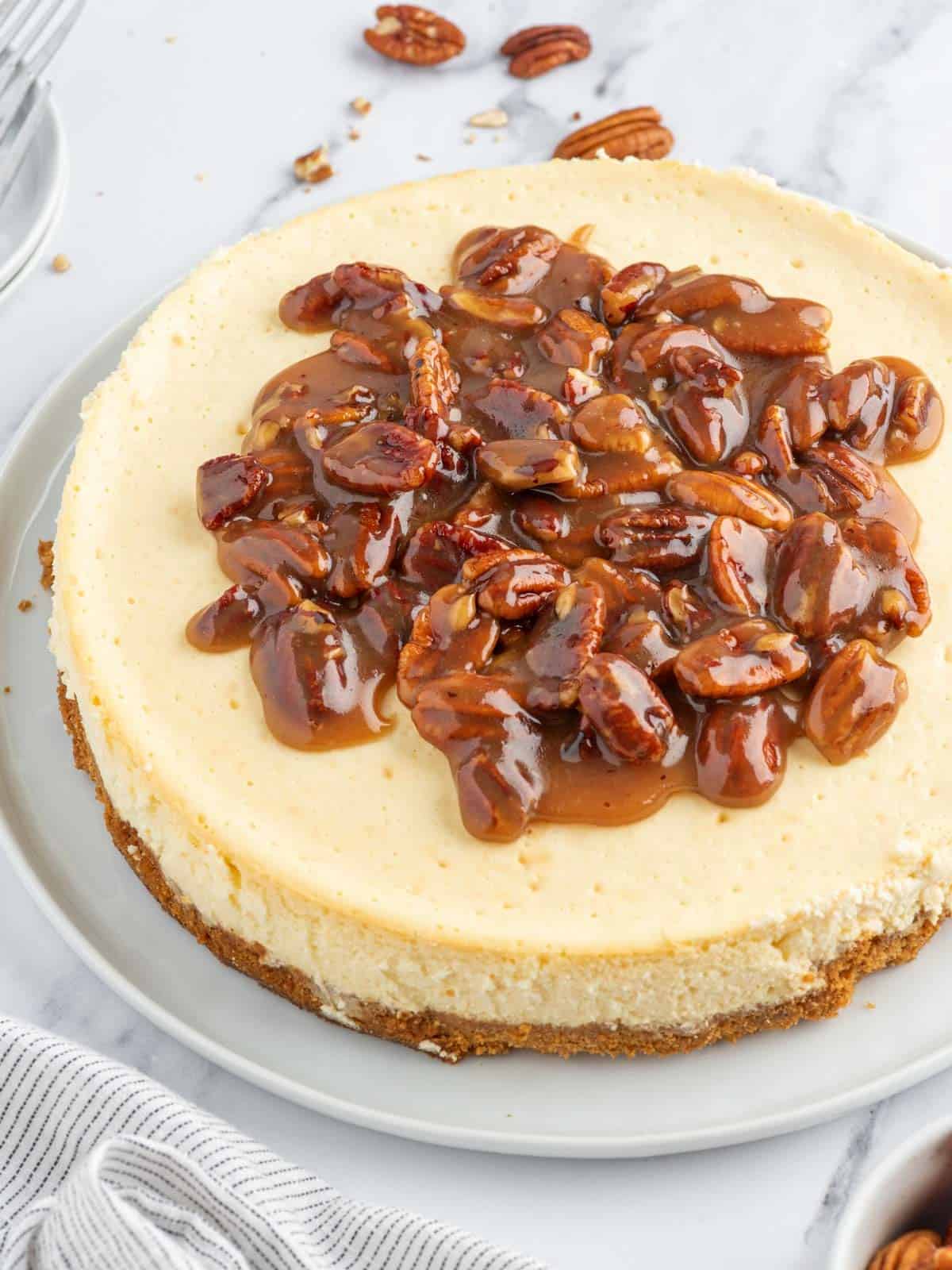 Pecan pie cheesecake on a platter for serving.