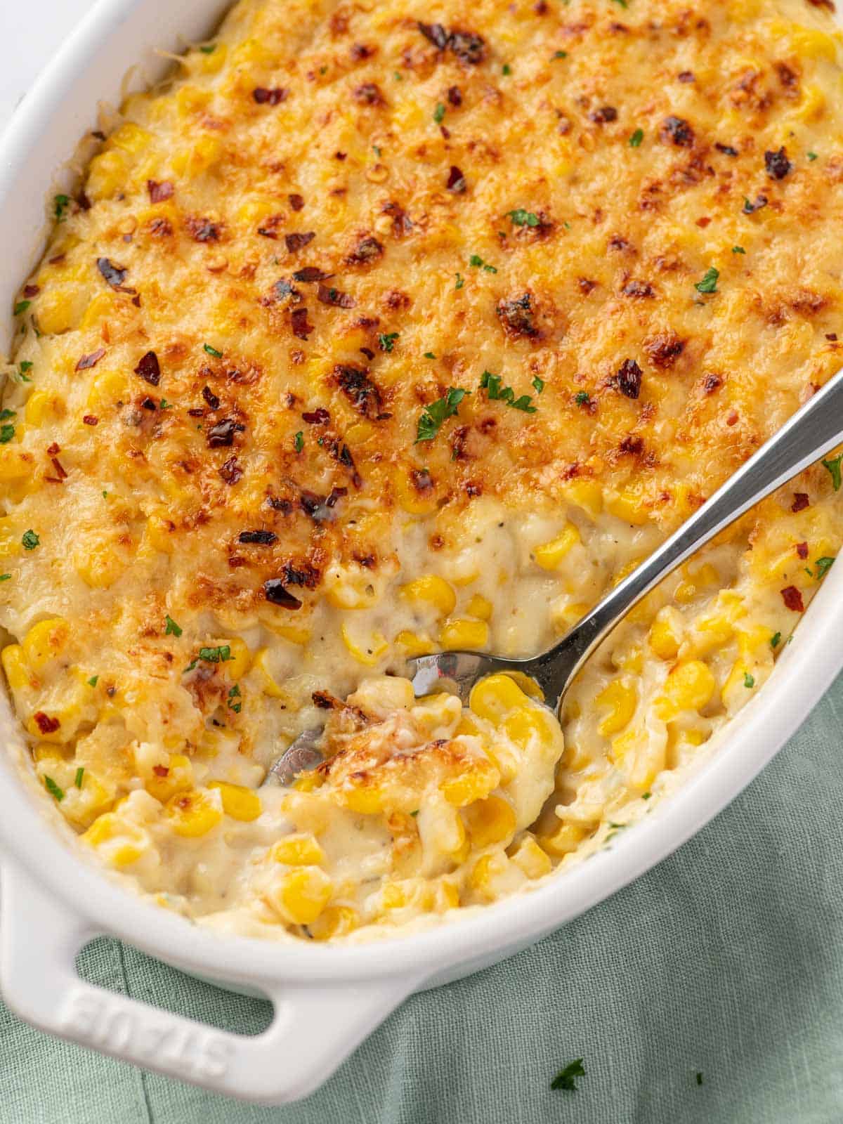 Creamy corn beneath a browned Parmesan topping with red pepper flakes and parsley.